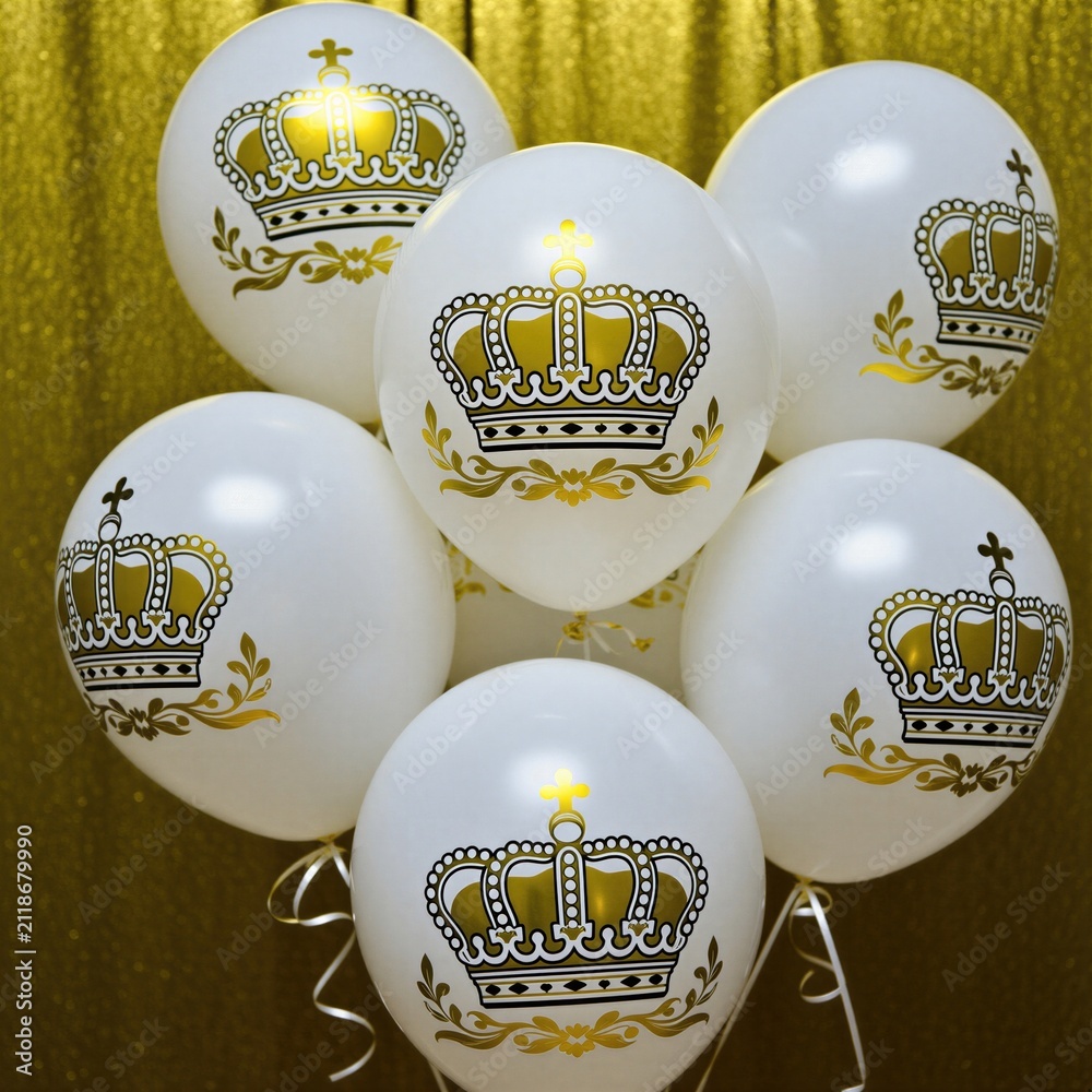 Obraz premium White balloons with gold crowns float indoors. Festive decor features royal imagery for parties, celebrations, and elegant events. Luxurious party decorations.