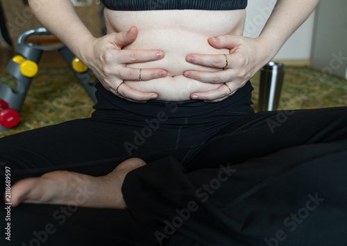 Bild auf Leinwand Woman demonstrating belly fat before doing yoga for weight loss and breathing exercises