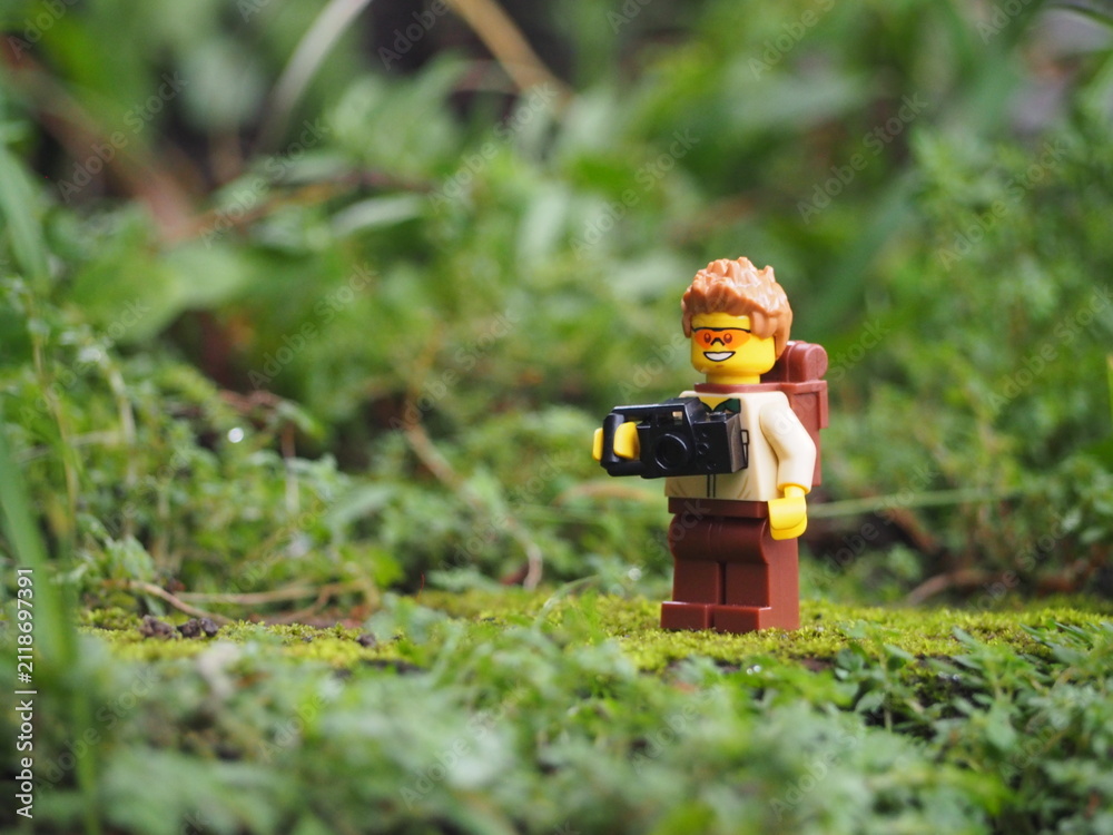 Fototapeta premium Indonesia - May 14, 2022 : Mini toy of action figure at grassland with blurred background. Toy photography concept. Adventure man concept design.