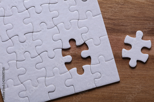 White blank puzzle on a wooden tray