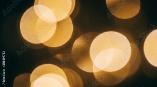 Abstract golden yellow bokeh lights glowing in the dark night as a decorative party or holiday background texture