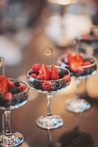 Lavish dessert display with fresh berries in elegant glasses during a festive evening gathering