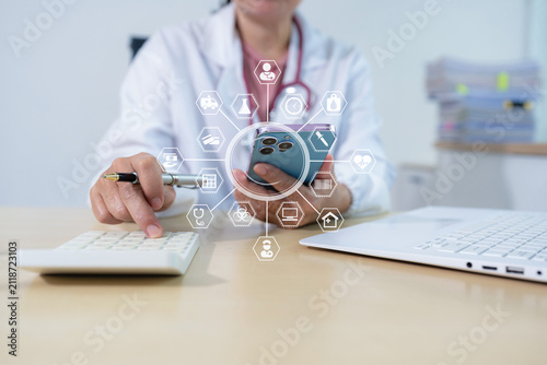 Doctor physician with stethoscope calculate medical fee costs and revenue. practitioner use calculator at Clinic.