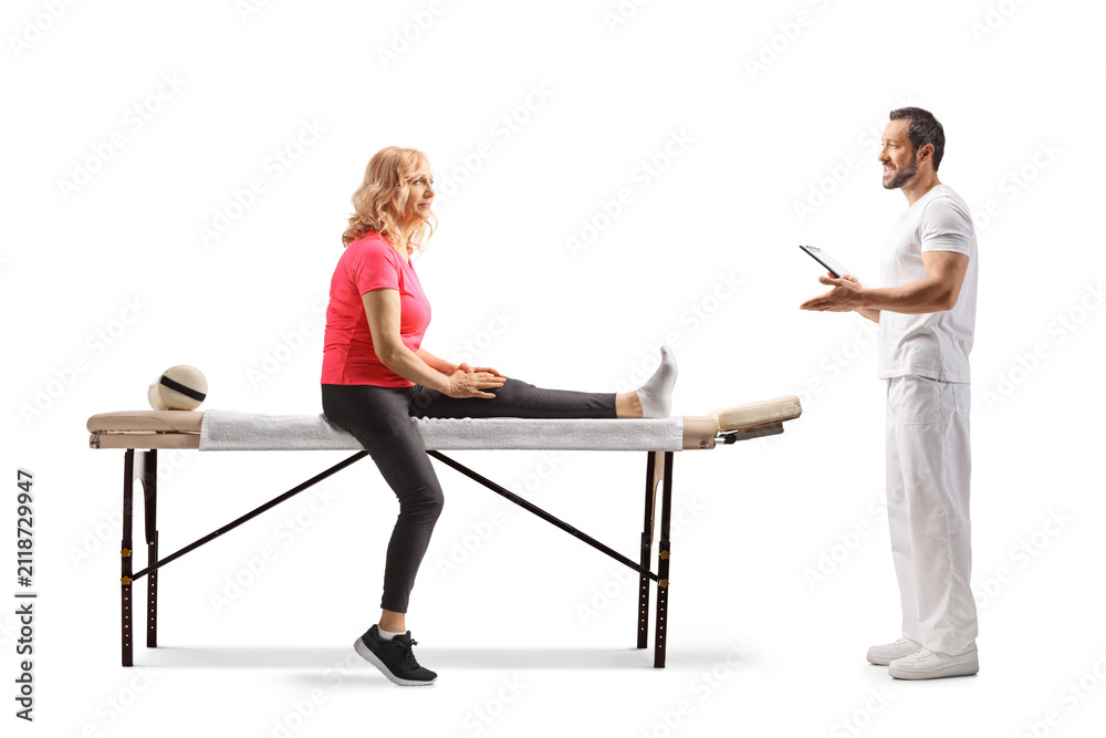 Obraz premium Physiotherapist talking to a female patient on a massage table
