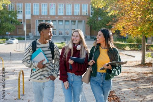 Diverse students walking on university campus discussing education