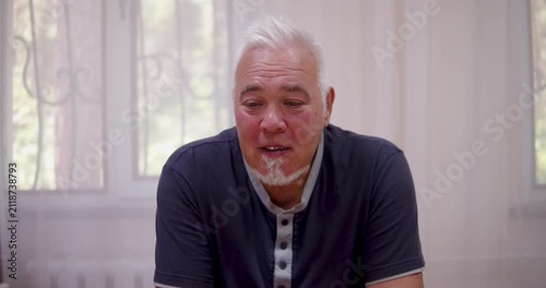 Close-up of a man sitting at a table and talking while looking at the camera.