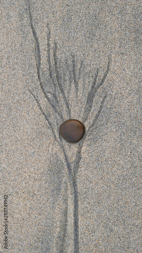 pebble on sand with natural tidal lines and abstract pattern