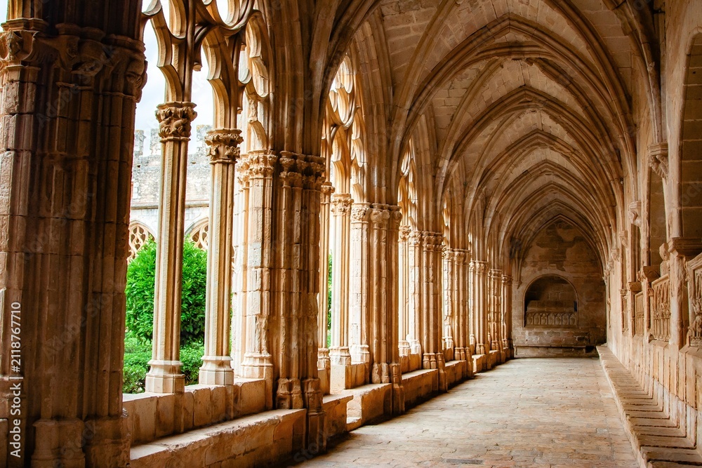 Fototapeta premium Stone columns defining the corridor with intricate arches in the historic monastery building