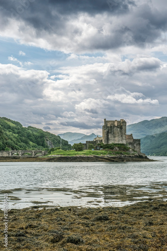 Eilean Donan Castle, a 13th century fortified tower house on a loch in the mountains.