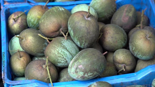 Fresh harvested velvet apples in a market crate