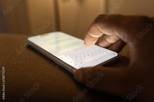 Man hands chatting and typing on smartphone macro closeup.