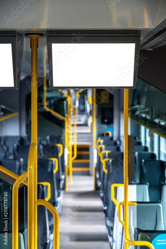 Mockup of blank screen in public transport setting with empty seats and poles