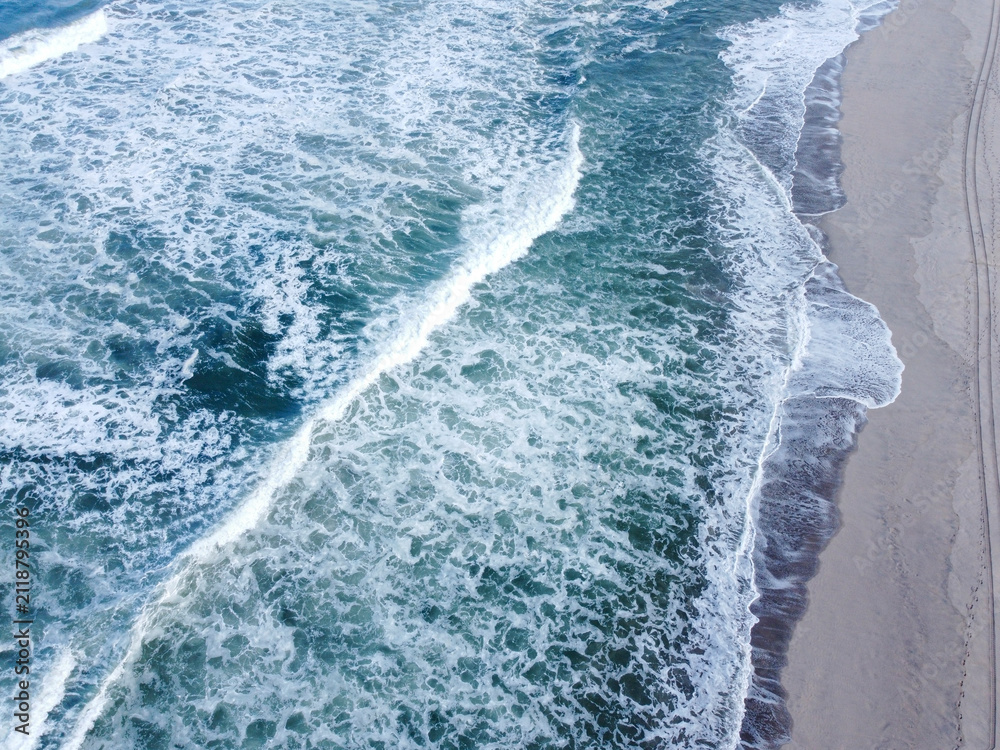 Fototapeta premium Aerial view of ocean waves on sandy beach The Concept of nature