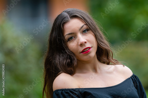 Young Woman Smiling in Off-Shoulder Top During Golden Hour in Urban Setting
