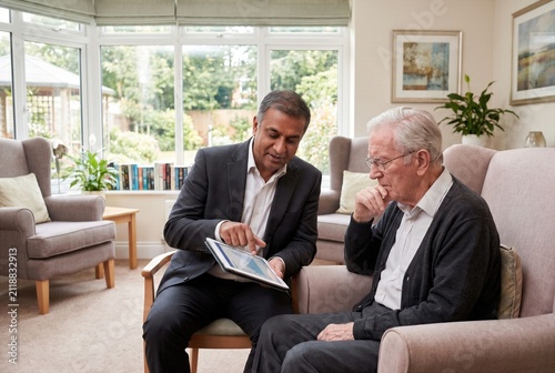 Financial advisor, bank manager, investment consultant insurance broker explaining financial plan to client or couple, discussing savings, loan, mortgage, investment, retirement, insurance