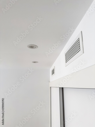 Obraz na płótnie A rectangular air diffuser mounted high on a white wall in a bright apartment