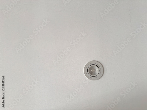 Canvastavla A recessed round downlight set into a white ceiling of a modern apartment