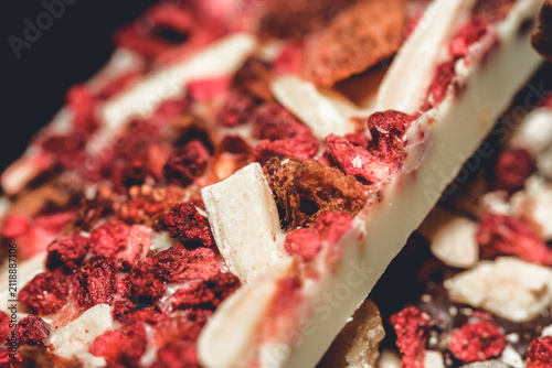 Artisan white chocolate bar with dried berries and nuts close-up detail