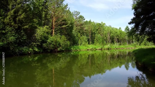 Drone shot of river in taiga surrounded by mountains and dense forest in summer. Scenic aerial view for travel, adventure and exploration concepts. Remote destination with wild untouched nature and be