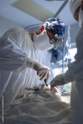 Canvastavla Focused surgeons performing intricate medical operation in a sterile operating theatre