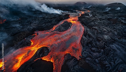 overhead view of fiery molten lava flowing through a dark volcanic field