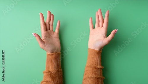 top view of hands reaching for something isolated on a green pastel background the concept of wanting to grab something gain