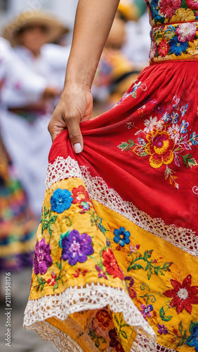 Colorful embroidered skirt in colombian flower festival parade, silletero tradition, floral textile craft, folkloric dance costume, lace detail, vibrant yellow fabric, cultural celebration