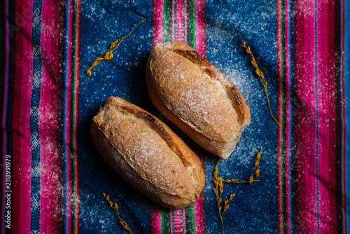 фотографія Bolivian marraqueta bread on an aguayo cloth decorated with wheat ears - food co