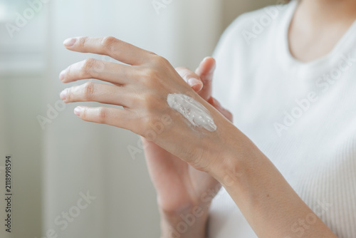 Foto Health skin care, beauty smile asian young woman, girl  hand applying, putting moisturizer on her arm, shoulder after shower bath at home