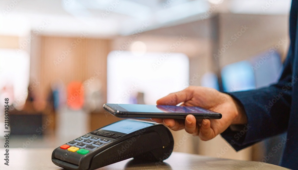Fototapeta premium Person Using Smartphone for Contactless Payment at POS Terminal