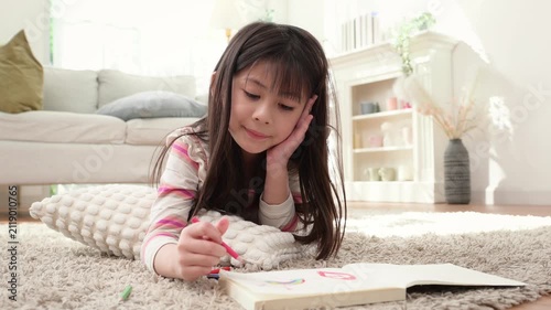 Child Drawing at Home on a Carpet in the Living Room During Daylight Hours