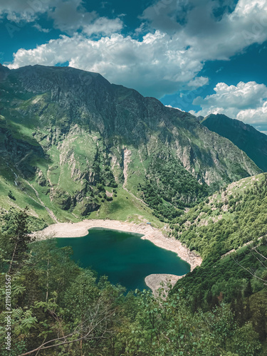 Canvas Print Aerial view of green mountains surrounding a turquoise lake, French Pyrenees