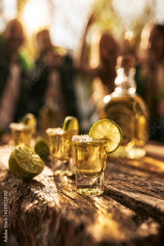 Friends enjoy margaritas and tequila shots during a summer celebration in an outdoor setting