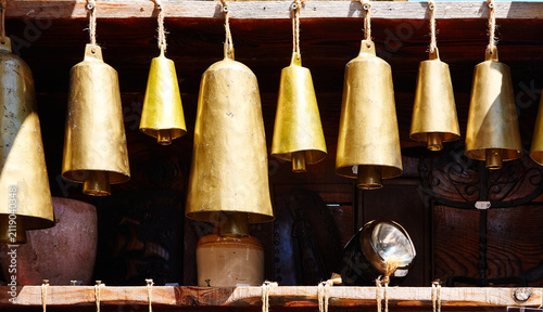 Fotografie Traditional Bulgarian cow brass bells displayed in a wooden showcase, showcasing