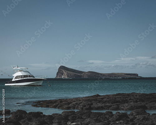 Fotografie Yacht sailing near a rocky headland on the coast