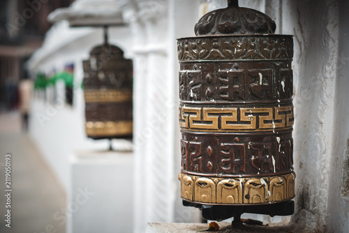 Konstfotografi Ornate Buddhist prayer wheel with carvings along a temple wall in Kathmandu