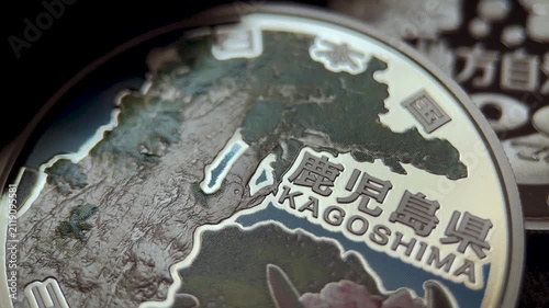 Japanese 1000 yen silver commemorative coin from the Local Autonomy series, featuring Kagoshima Prefecture map details, engraved lettering, colorful floral artwork, and collectible numismatic texture.