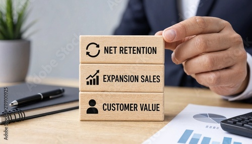 Professional analyzing business metrics with net retention expansion sales and customer value wooden blocks on desk