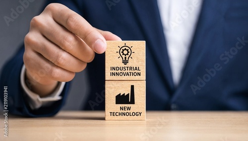Professional hand placing wooden blocks emphasizing industrial innovation and new technology concepts on a desk