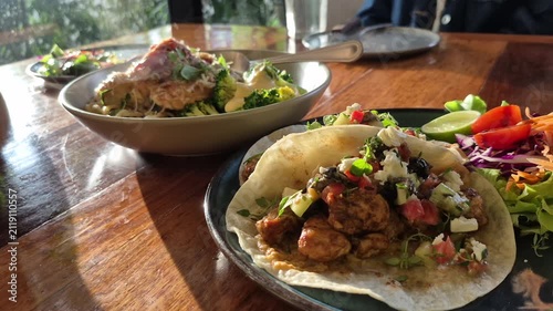 Taco and chicken spaghetti American diner's style food on wood table and sun light