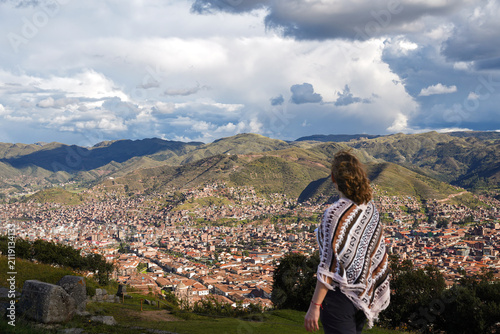 Fotografía Female traveler admiring panoramic view of Cusco city and Andes mountains in Per