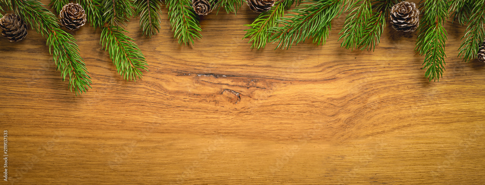 Fototapeta premium Christmas Pine Branches Framing Rustic Wooden Background
