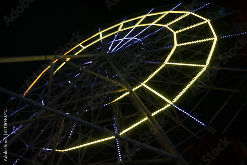 фотографія Low angle view of illuminated Ferris wheel at night against dark sky