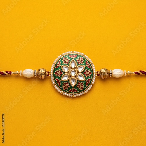Premium Handcrafted Indian Rakhi on Vibrant Yellow Background Product Photography Composition.