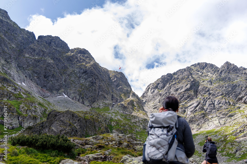 Fototapeta premium Hikers Watching Rescue Helicopter in High Tatra Mountains