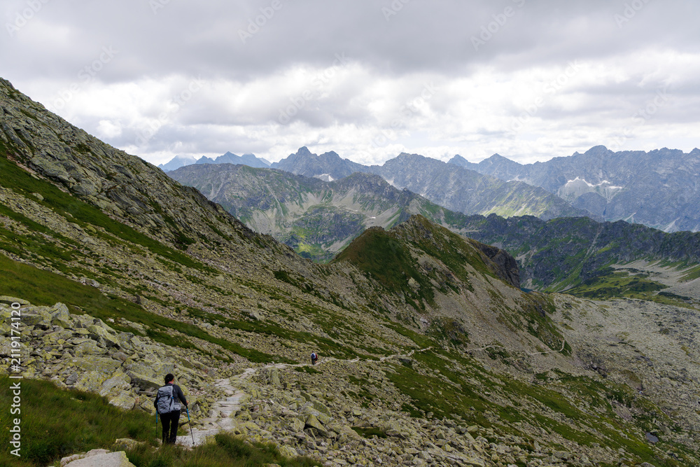 Fototapeta premium Hiker descending rocky mountain path in High Tatras