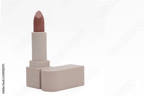 Beige lipstick in a beige container. On a white background. Close-up.