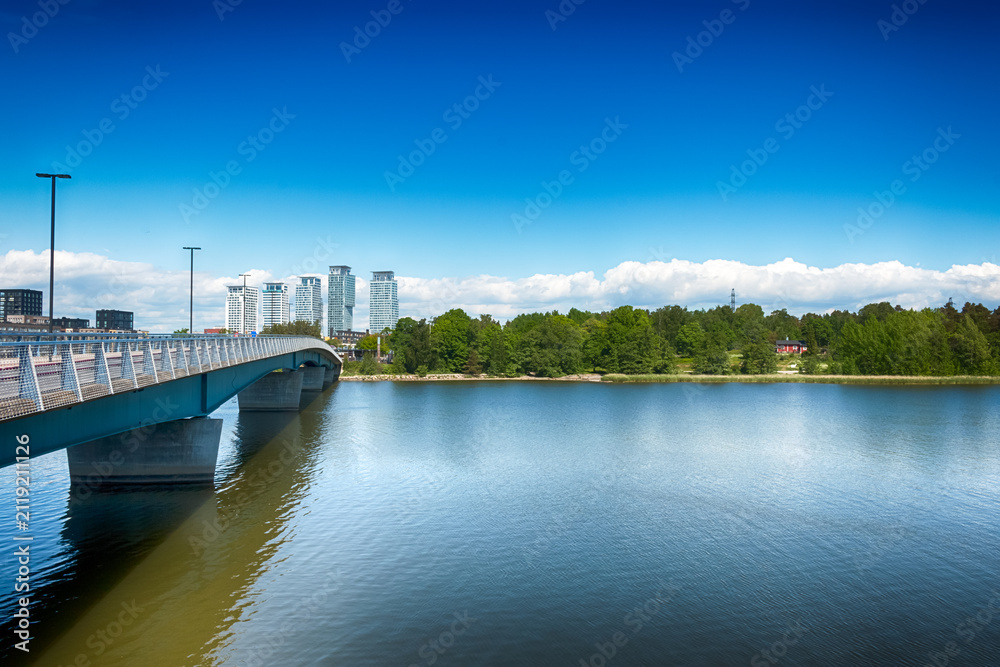 Fototapeta premium A view of the Korkeasaarensilta bridge connecting the island of Korkeasaari over calm waters in Helsinki, Finland, on a bright, sunny day. HDR.