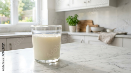 Glass of fresh cow milk on a kitchen counter. Healthy dairy drink in a clear glass.