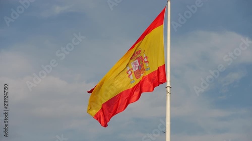 Spanish flag waving in the wind against a blue sky